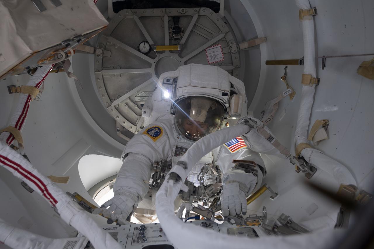 iss061e011927 (Oct. 18, 2019) --- NASA astronaut Jessica Meir prepares to exit the crew lock portion of the Quest airlock into the vacuum of space. She and fellow NASA astronaut Christina Koch (out of frame) conducted a spacewalk for seven hours and 17 minutes to swap a failed battery charge-discharge unit (BCDU) with a spare during the first all-woman spacewalk. The BCDU regulates the charge to the batteries that collect and distribute solar power to the orbiting lab’s systems.