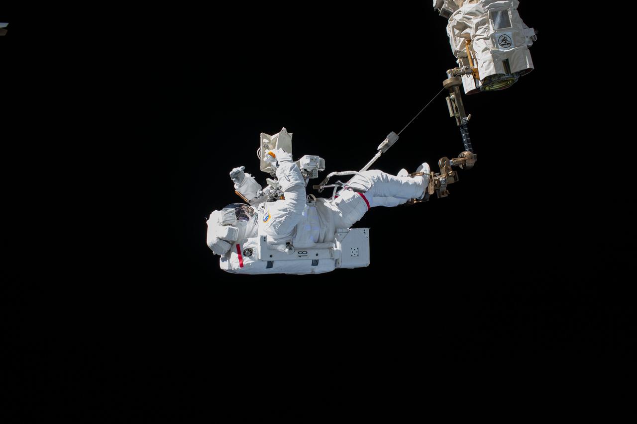 iss061e045275 (Nov. 15, 2019) --- ESA (European Space Agency) astronaut Luca Parmitano is pictured attached to the Canadarm2 robotic arm during the first spacewalk to repair the Alpha Magnetic Spectrometer, the International Space Station's cosmic particle detector.