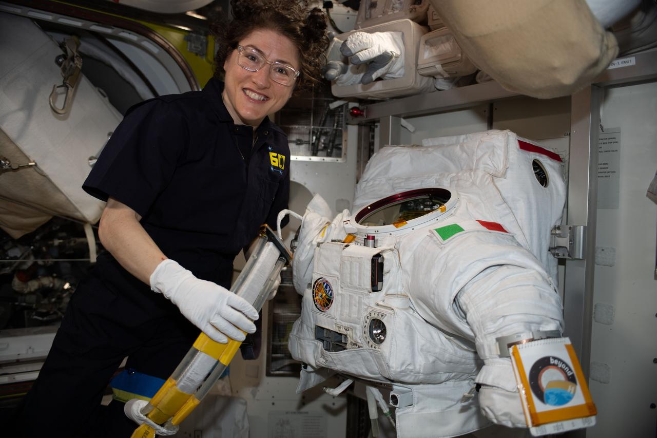 iss061e067498 (Dec. 5, 2019) --- NASA astronaut Christina Koch works on a U.S. spacesuit, with a patch of the Italian flag on the left shoulder, that Commander Luca Parmitano of ESA (European Space Agency) wore during a spacewalk on Dec. 2, 2019.