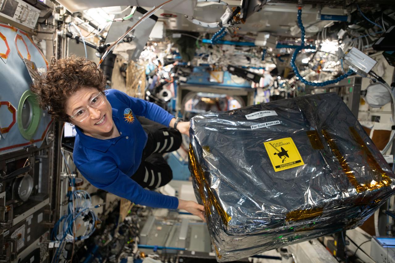 iss061e068045 (Dec. 9, 2019) --- NASA astronaut and Expedition 61 Flight Engineer Christina Koch handles science hardware stowed inside a cargo transfer bag retrieved from the SpaceX Dragon resupply ship. The hardware is part of the the Cold Atom Laboratory that produces clouds of atoms that are chilled to about one ten billionth of a degree above absolute zero -- much colder than the average temperature of deep space. At these low temperatures, atoms have almost no motion, allowing scientists to study fundamental behaviors and quantum characteristics that are difficult or impossible to probe at higher temperatures.
