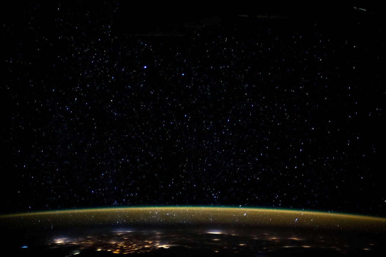 iss061e110433 (Dec. 29, 2019) --- Stars glitter in the night sky above an atmospheric glow that blankets the city lights as the International Space Station orbited 259 miles above the Sudanese/Egyptian border before it crossed the Red Sea.