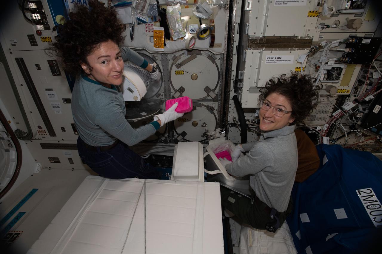 iss061e120287 (Jan. 6, 2020) --- NASA astronauts (from left) Jessica Meir and Christina Koch work inside the Kibo laboratory module collecting frozen biological samples for stowage inside the SpaceX Dragon resupply ship. Dragon parachuted to a splashdown in the Pacific Ocean the following day on Jan. 7, 2020.