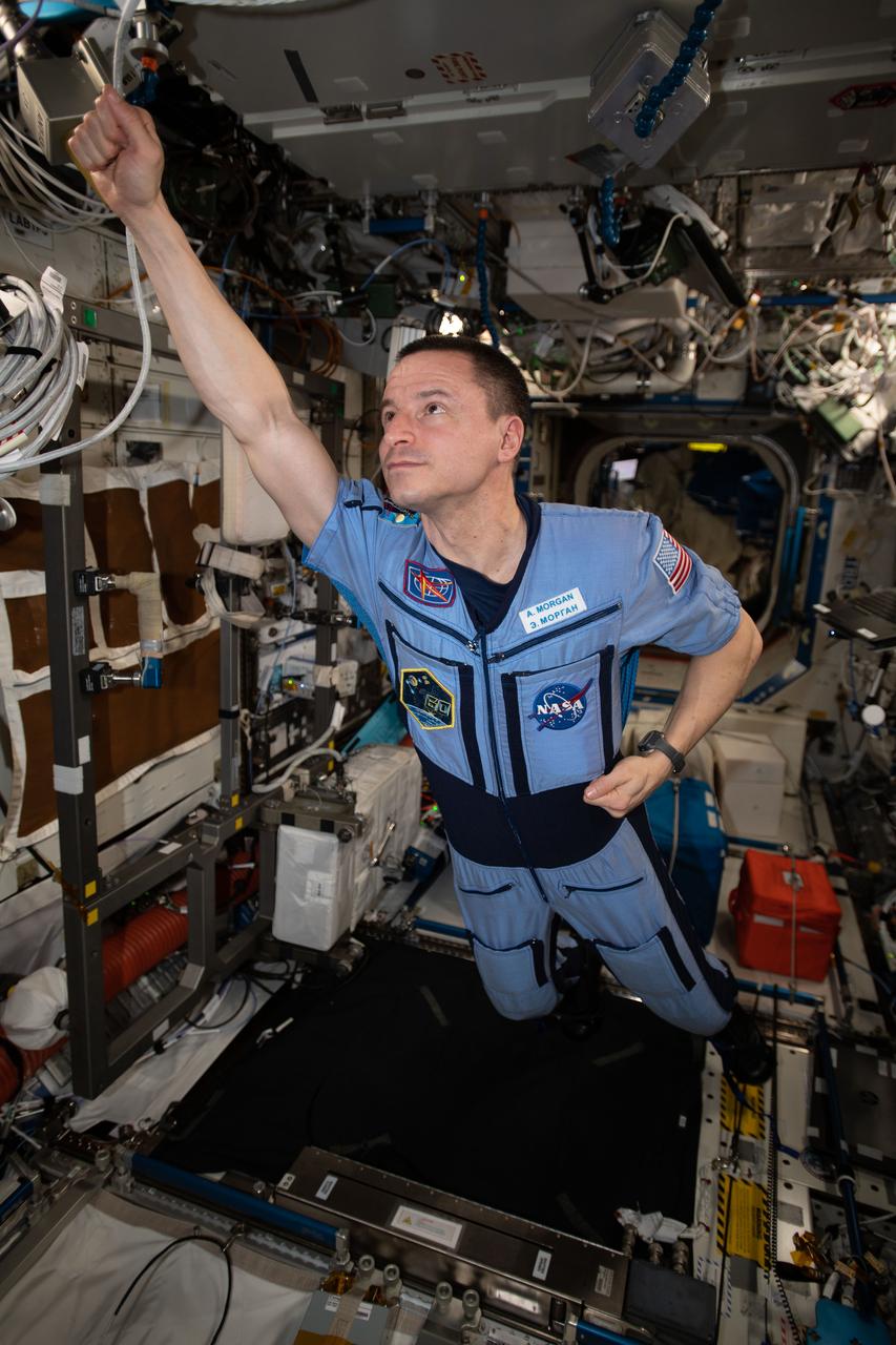 iss062e116020 (March 29, 2020) --- NASA astronaut and Expedition 62 Flight Engineer Andrew Morgan strikes a superhero pose in the weightless environment of the International Space Station.
