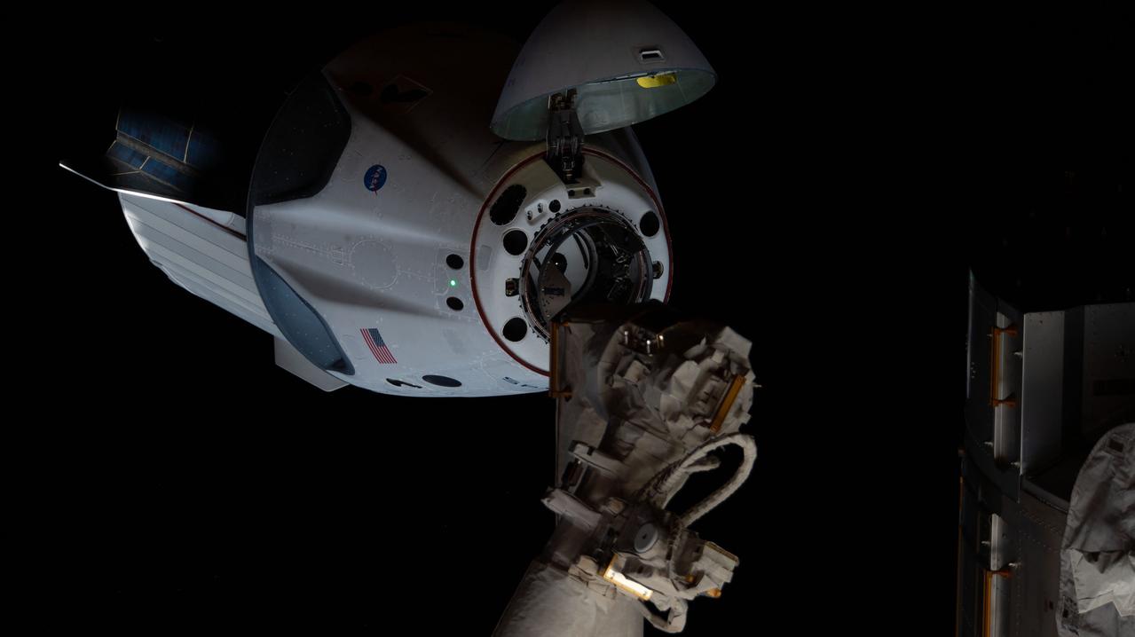 iss063e021463 (May 31, 2020) --- Astronauts Doug Hurley and Bob Behnken of NASA's Commercial Crew Program were aboard the SpaceX Crew Dragon as it approached the International Space Station. The Crew Dragon's nose cone is open revealing the spacecraft's docking mechanism that would connect to the Harmony module's forward International Docking Adapter.