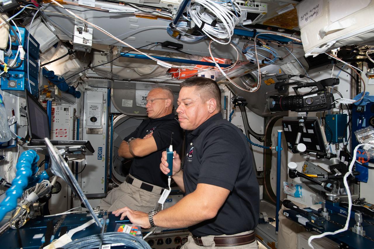 iss063e022389 (June 1, 2020) --- NASA astronauts Bob Behnken (foreground) and Doug Hurley, who flew the Crew Dragon spacecraft to the International Space Station during SpaceX Demonstration Mission-2, are pictured briefing mission controllers about their experience in the new vehicle.