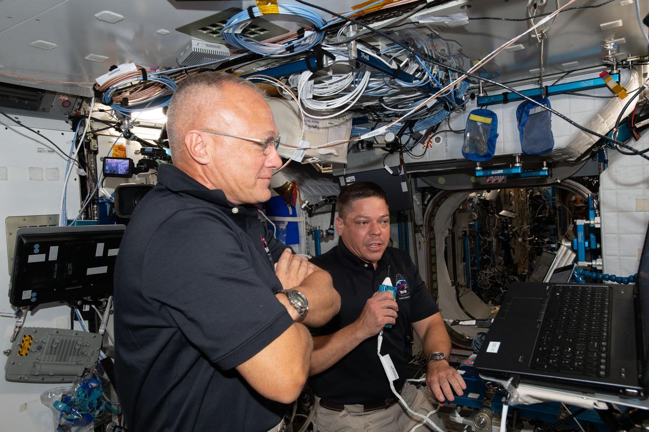 iss063e022398 (June 1, 2020) --- NASA astronauts Doug Hurley (foreground) and Bob Behnken, who flew the Crew Dragon spacecraft to the International Space Station during SpaceX Demonstration Mission-2, are pictured briefing mission controllers about their experience in the new vehicle.