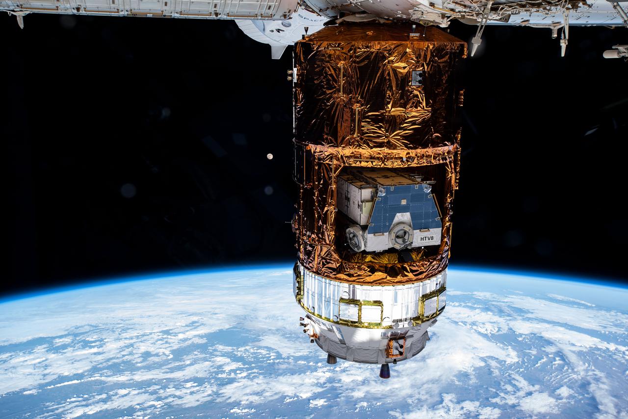 iss063e024519 (June 4, 2020) --- Japan's resupply ship, the H-II Transfer Vehicle-9 (HTV-9), is pictured attached to the International Space Station's Harmony module dwarfing the Moon behind it. Stowed inside the Japanese space freighter is the HTV-8 cargo pallet that was brought up to the station on a previous resupply mission. The pallet contains old nickel-hydrogen batteries for disposal that were disconnected from the station during a series of spacewalks at the end of 2019. Nearly hidden at the top center is the SpaceX Crew Dragon vehicle.