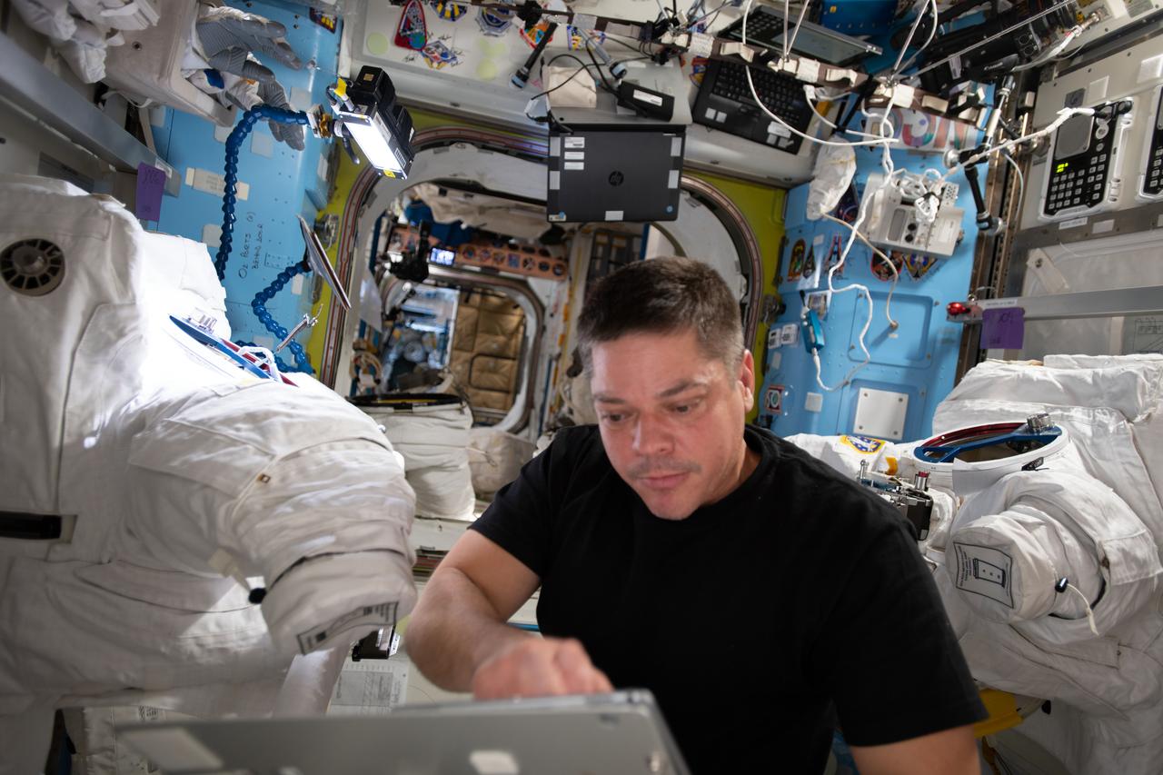 iss063e030591 (June 18, 2020) --- NASA astronaut and Expedition 63 Flight Engineer Bob Behnken reviews maintenance procedures on a computer while working on U.S. spacesuits inside the International Space Station's Quest airlock.