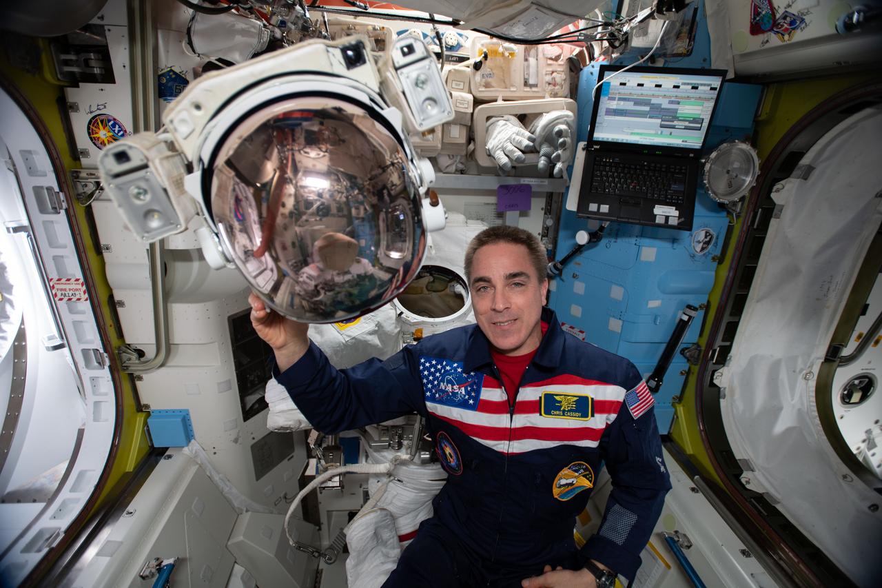 iss063e033672 (June 28, 2020) --- NASA astronaut and Expedition 63 Commander Chris Cassidy shows off the helmet of a U.S. spacesuit during maintenance inside the Quest airlock.