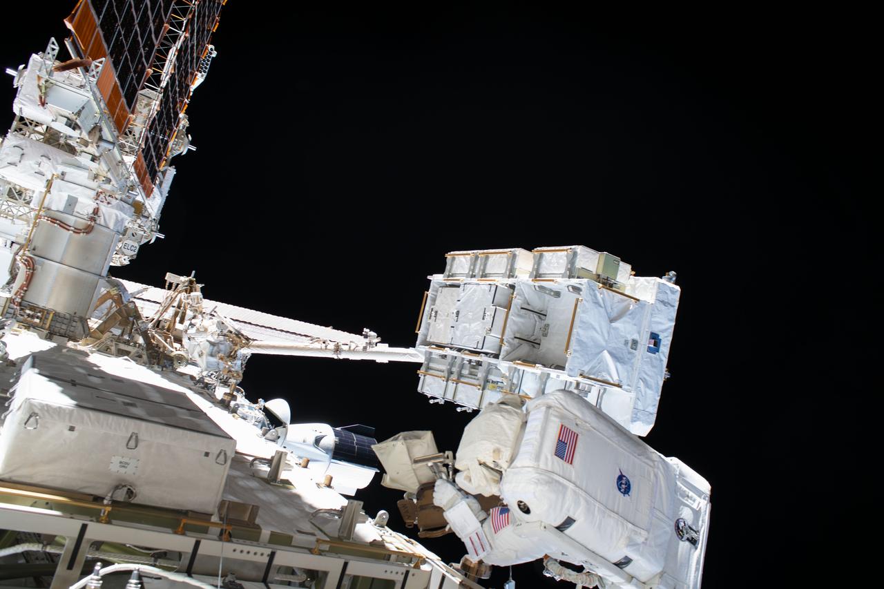 iss063e034050 (July 1, 2020) --- NASA astronaut and Expedition 63 Flight Engineer Bob Behnken (bottom right) works during a six-hour and one-minute spacewalk to swap an aging nickel-hydrogen battery for a new lithium-ion battery on the International Space Station's Starboard-6 truss structure. Behind Behnken is an external pallet, attached to the Canadarm2 robotic arm, where the batteries were stowed.