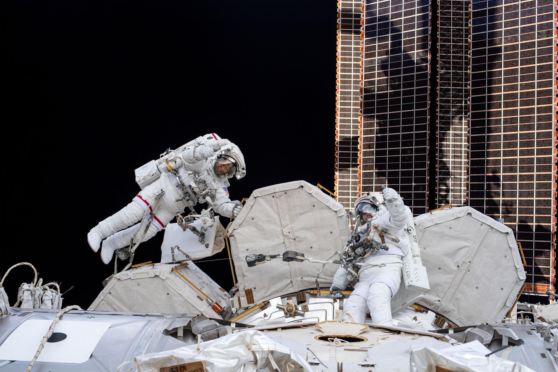 NASA spacewalkers (from left) Bob Behnken and Chris Cassidy give a thumbs up during a spacewalk to install hardware and upgrade International Space Station systems.