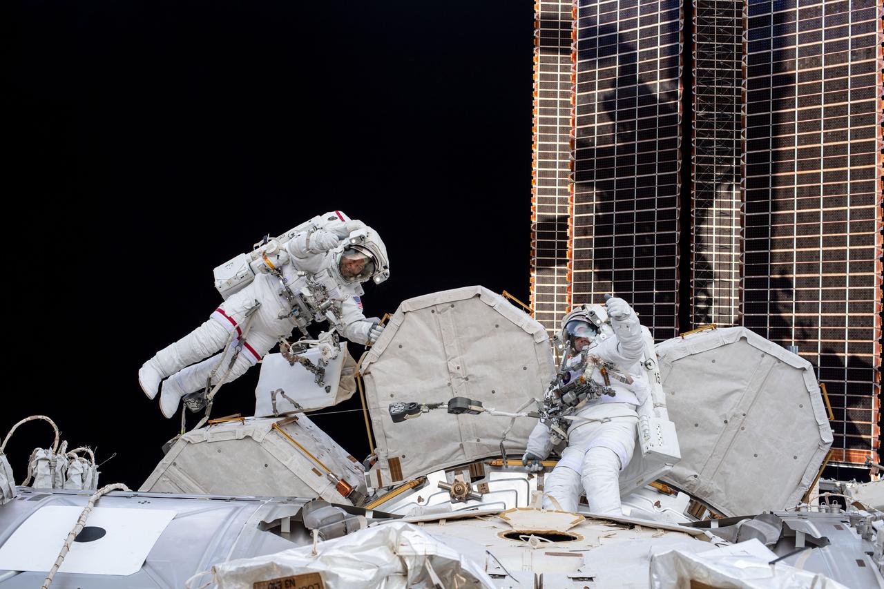iss063e053998 (July 21, 2020) --- NASA spacewalkers (from left) Bob Behnken and Chris Cassidy give a thumbs up during a spacewalk to install hardware and upgrade International Space Station systems. This photograph was taken by an Expedition 63 crew member inside the cupola, the orbiting lab's "window to the world."