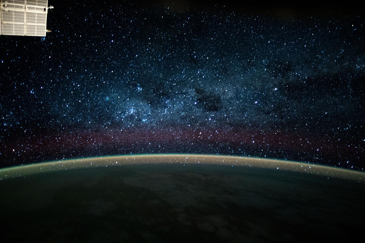 iss063e054340 (July 23, 2020) --- This long-exposure photograph during an orbital night period from the International Space Station reveals a wispy, but colorful atmospheric glow crowning Earth's horizon back-dropped by the dazzling Milky Way.