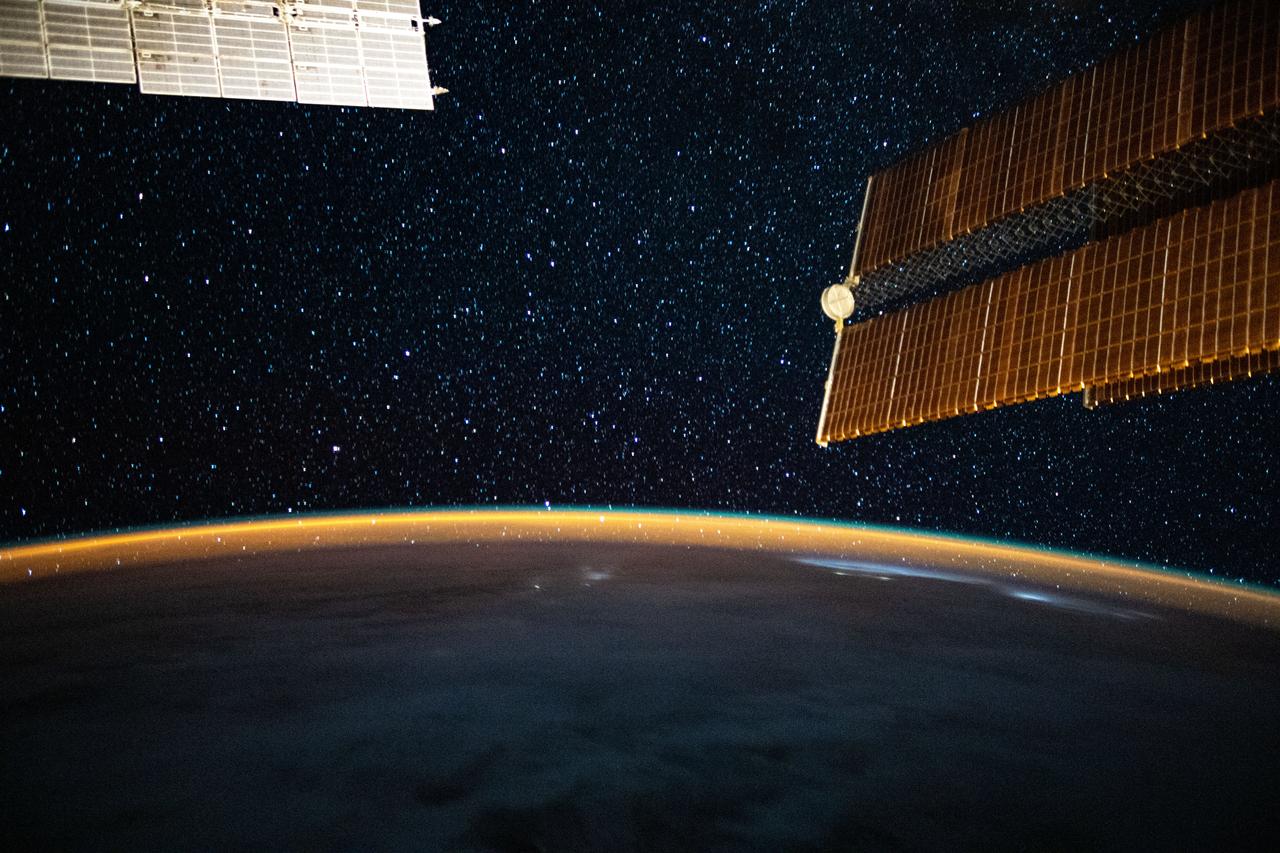 iss063e058430 (July 24, 2020) --- This long-exposure photograph from the International Space Station was taken during an orbital night period and reveals the Milky Way glittering above a bright but exaggerated atmospheric glow blanketing the Earth's horizon.