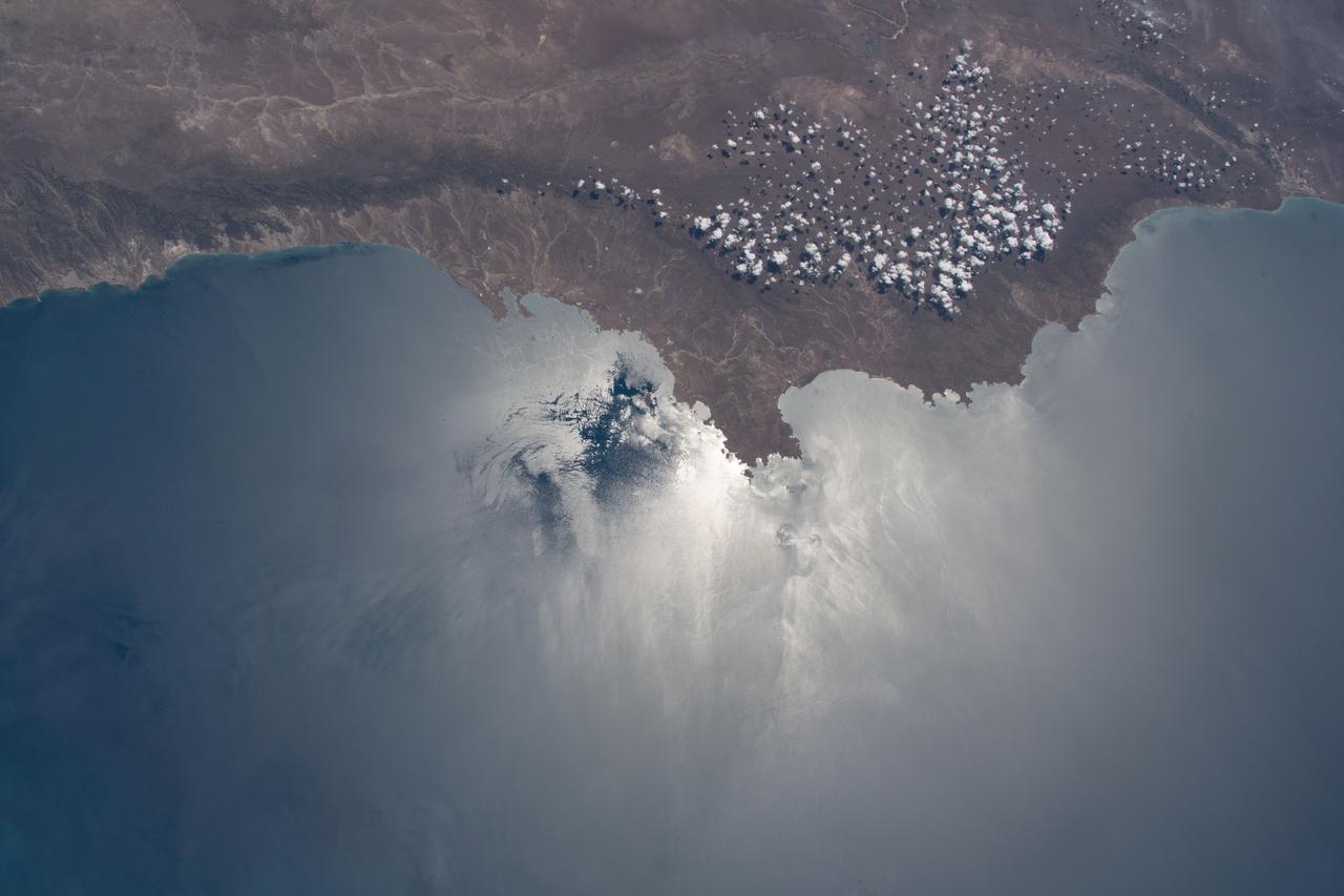iss064e003749 (Nov. 8, 2020) --- The coast of Chubut Province in Argentina, with the Sun's glint beaming off the Golfo San Jorge and Bahia Camarones, is pictured as the International Space Station orbited above the Argentine Sea.