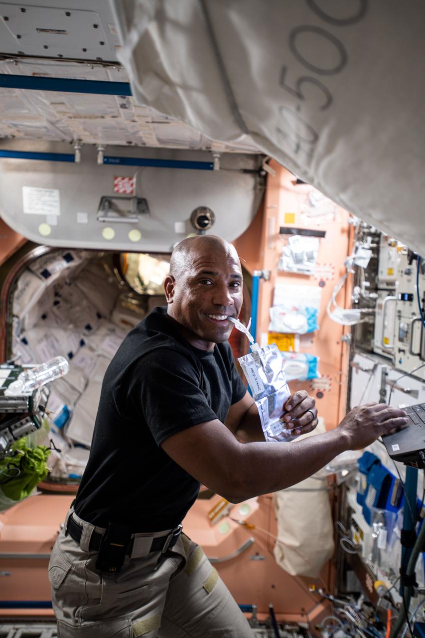 iss064e005045 (Nov. 20, 2020) --- SpaceX Crew-1 Pilot and Expedition 64 Flight Engineer Victor Glover of NASA sips on a water bag while familiarizing himself with systems and procedures during his first week aboard the International Space Station.