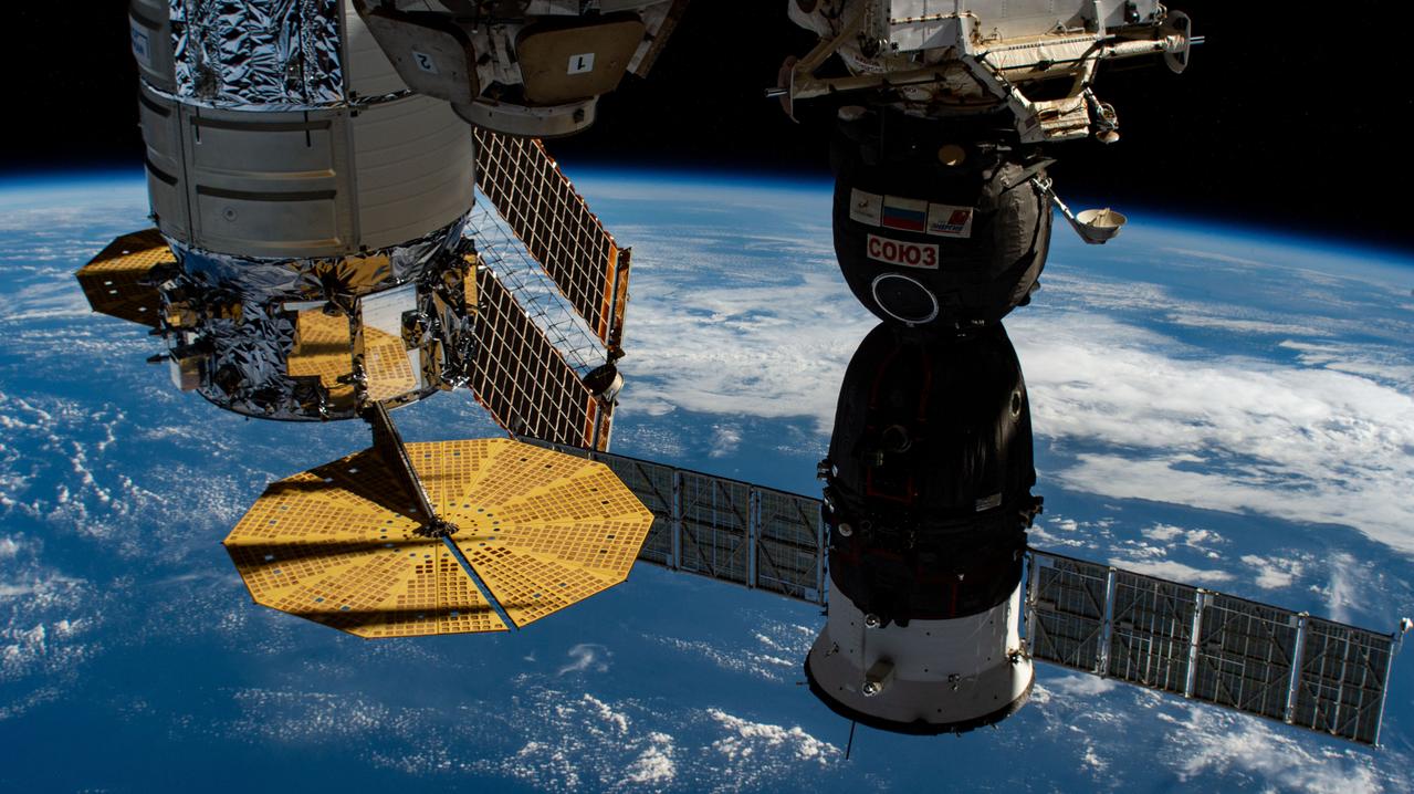 iss064e006373 (Nov. 26, 2020) --- A U.S. and a Russian spacecraft are pictured docked to the International Space Station as it orbited above the Pacific Ocean southwest of Baja California. At left is the Northrop Grumman Cygnus cargo craft with its two prominent cymbal-shaped solar arrays, and next to it is Russia's Soyuz MS-17 crew ship with its rectangular solar arrays.