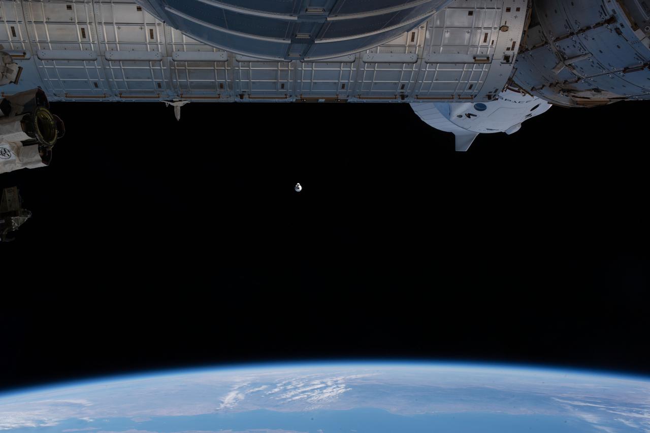 iss064e010904 (Dec. 7, 2020) --- The upgraded SpaceX Cargo Dragon vehicle approaches the International Space Station as both vehicles were orbiting above the Pacific Ocean off the coast of Mexico. Near the top right of the photograph is a portion of the SpaceX Crew Dragon vehicle docked to the forward port of the Harmony module. The Cargo Dragon would dock about an hour later to Harmony's space-facing port marking the first time two Dragon spaceships would be docked to the station at the same time.