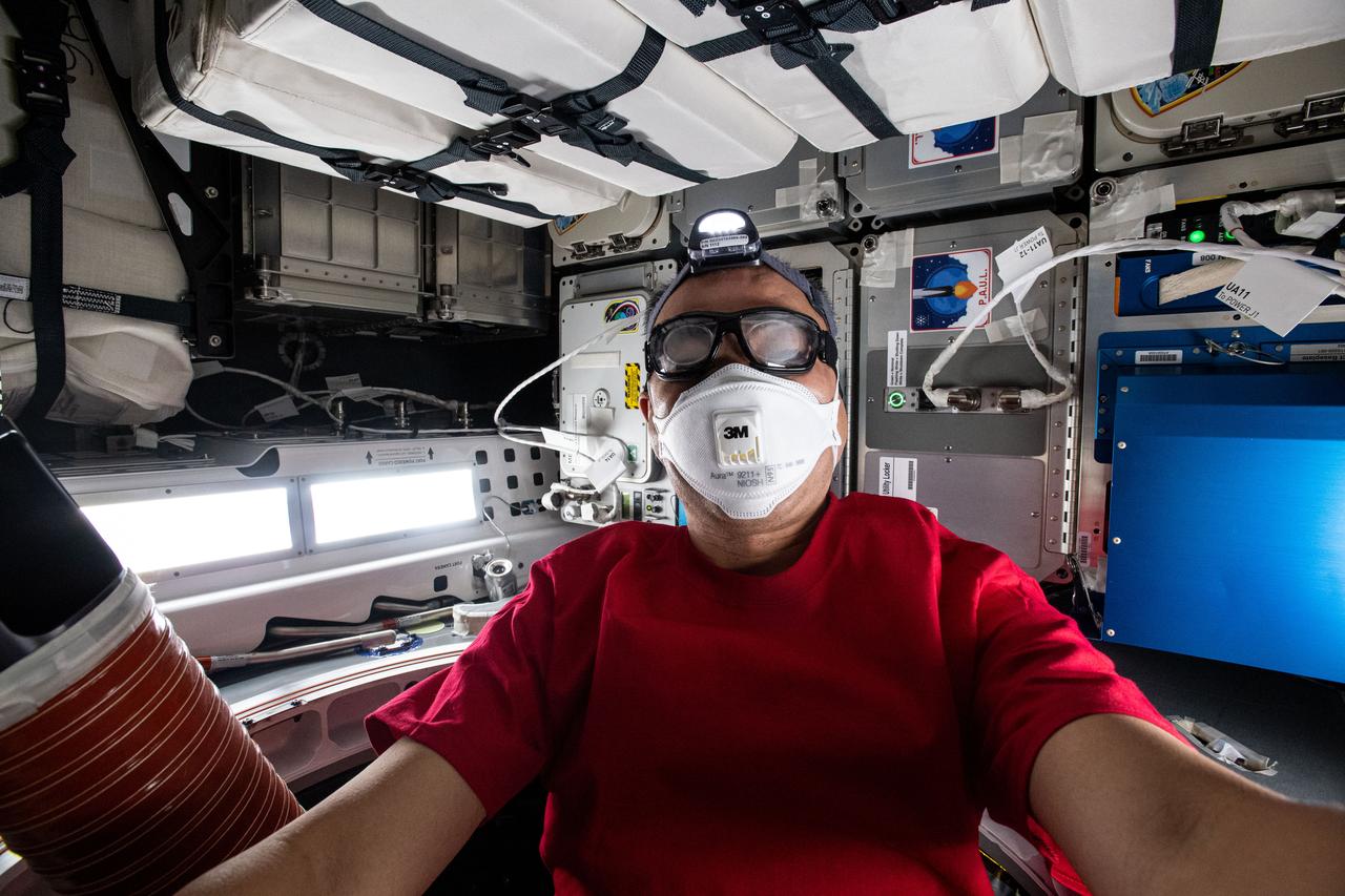 iss064e011228 (Dec. 7, 2020) --- JAXA astronaut Sochi Noguchi is pictured inside the newly arrived SpaceX Cargo Dragon vehicle wearing personal protective equipment. Safety goggles and masks are required when a crew member opens the hatch and enters a new spacecraft for the first time due to dust and debris that may have been dislodged during the ascent to space.