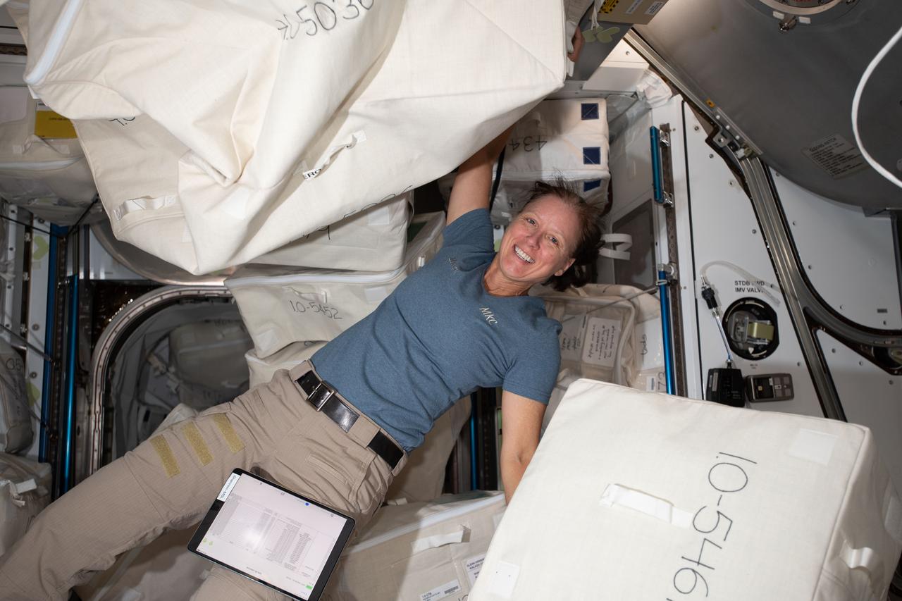 iss064e012018 (Dec. 14, 2020) --- NASA astronaut and Expedition 64 Flight Engineer Shannon Walker unpacks spacewalk hardware inside the Quest airlock where U.S. spacewalks are staged.