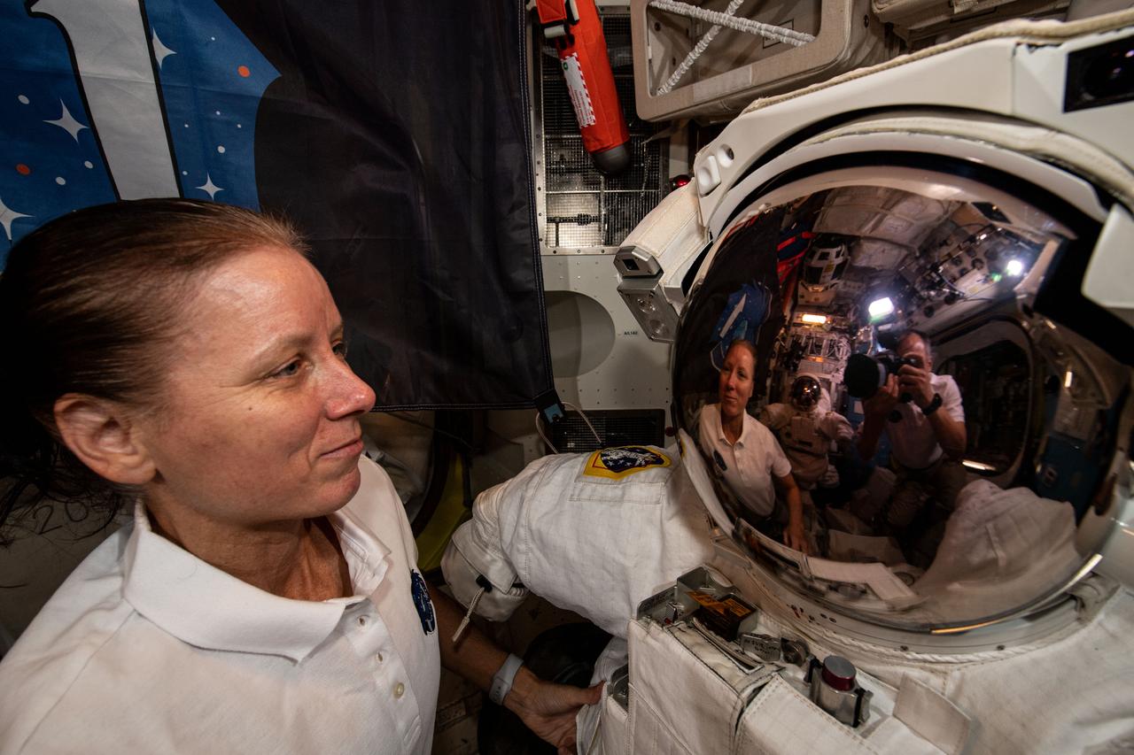 iss064e016099 (Dec. 27, 2020) --- This unique portrait shows NASA astronaut Shannon Walker reflected in a U.S. spacesuit helmet along with her photographer JAXA astronaut Soichi Noguchi during maintenance operations inside the International Space Station's Quest airlock.