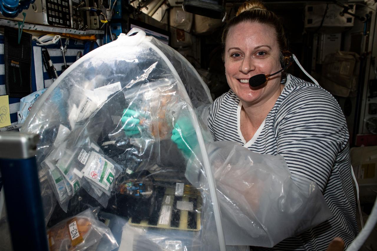 iss064e016824 (Dec. 30, 2020) --- NASA astronaut Kate Rubins is pictured conducting science operations inside the portable glovebox to contain the accidental spillage of materials and prevent exposing the International Space Station's environment to biological samples.