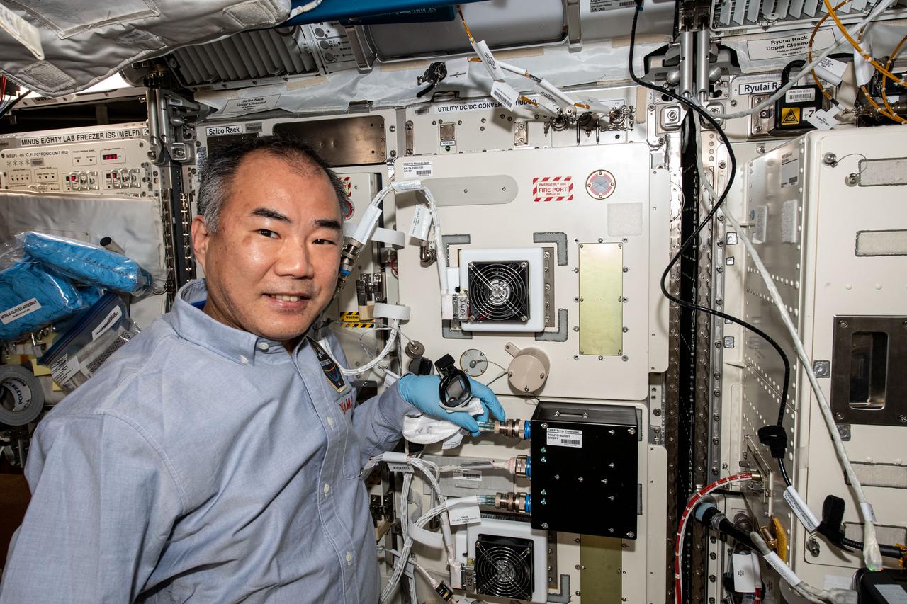 iss064e020149 (Jan. 5, 2021) --- JAXA (Japan Aerospace Exploration Agency) astronaut Soichi Noguchi works inside the Kibo laboratory module servicing a science freezer that stores and preserves biological samples for later analysis.