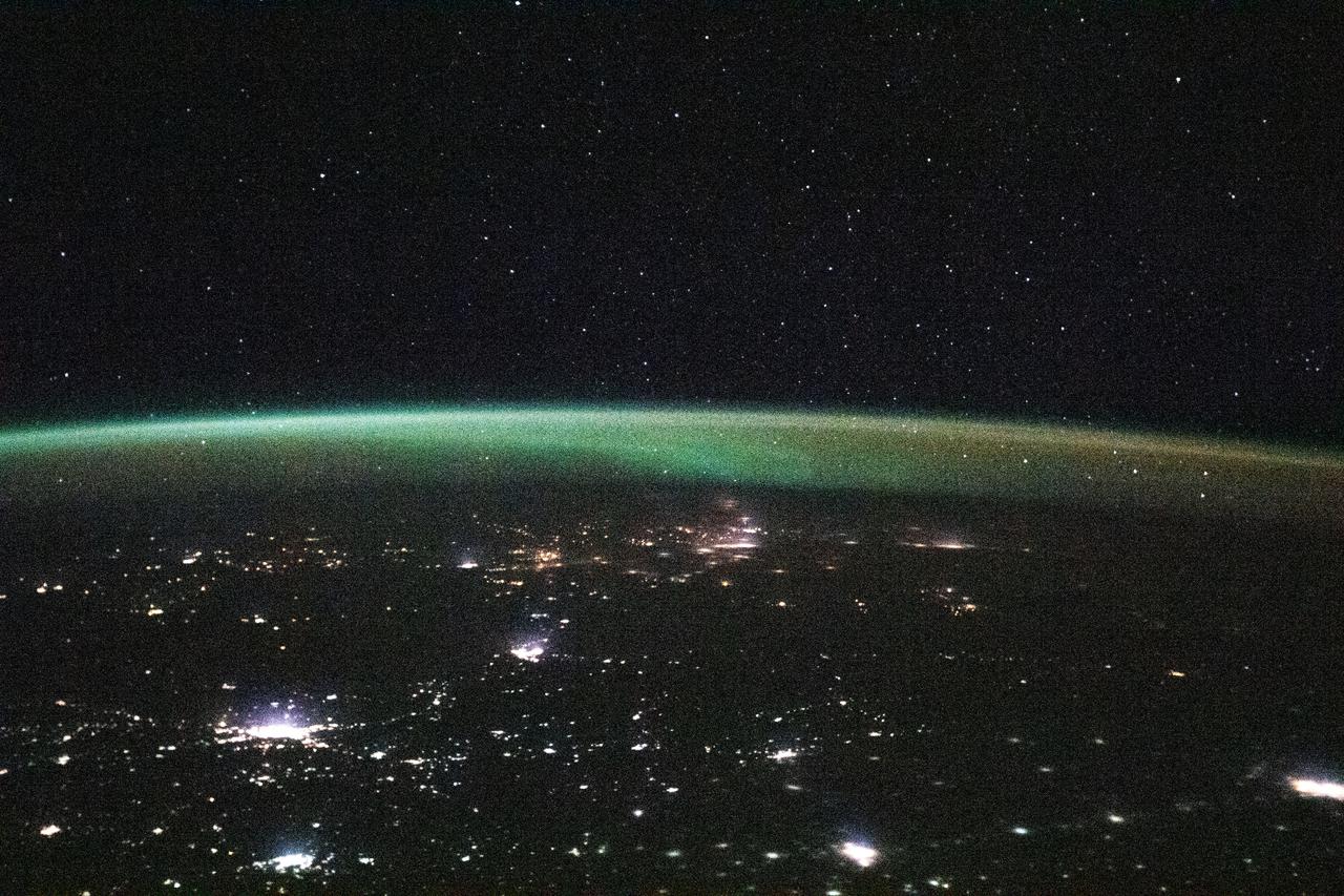 iss064e023203 (Jan. 13, 2021) --- This view from the International Space Station, as it orbited 264 miles above Kazakhstan, looks north towards Russia with its brightly lit cities blanketed by an aurora.