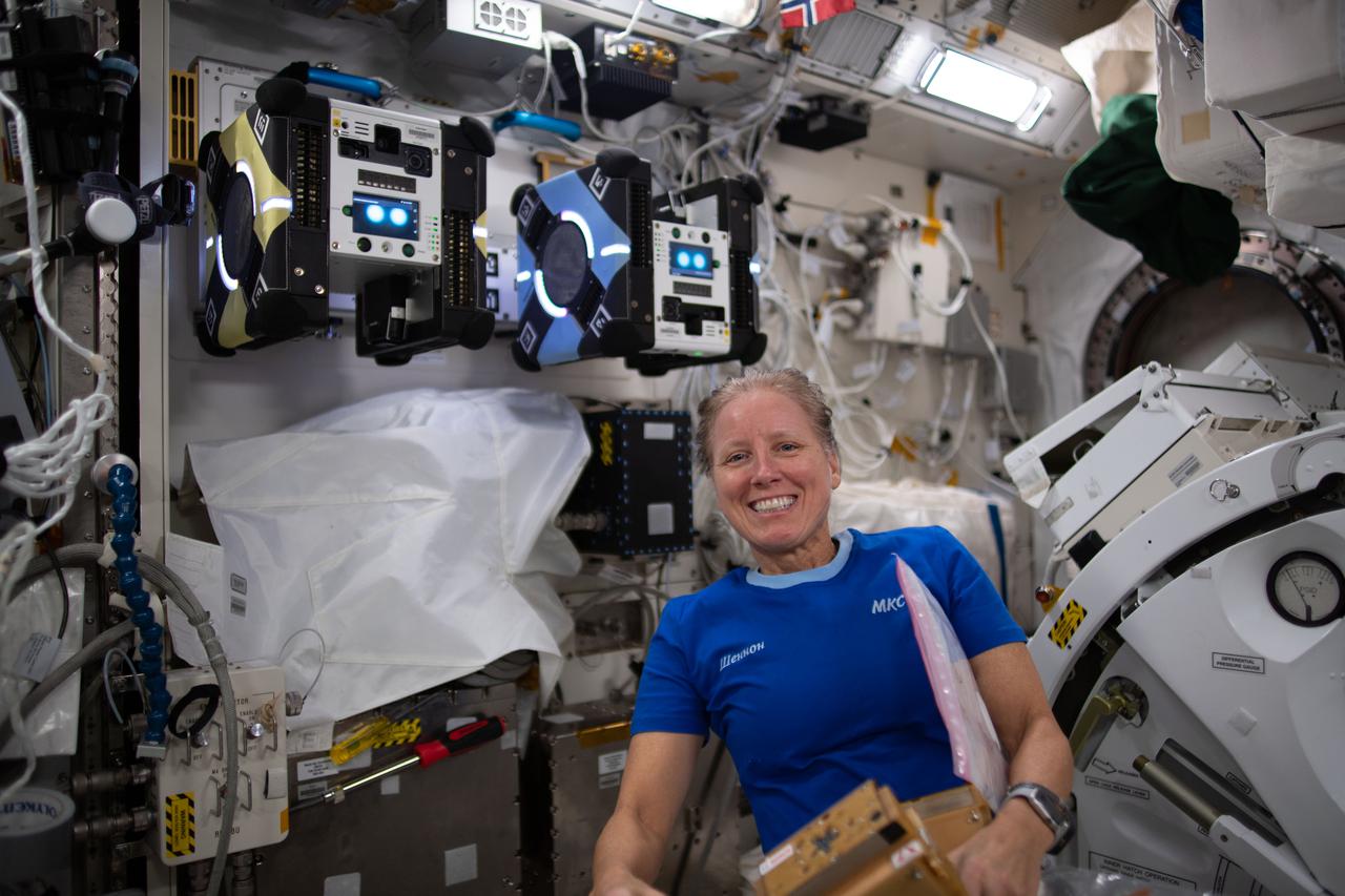 iss064e023424 (Jan. 18, 2021) --- NASA astronaut and Expedition 64 Flight Engineer Shannon Walker poses with a pair of free-flying, cube-shaped robots that are part of the Astrobee study that is investigating their ability navigate autonomously and assist astronauts with routine chores aboard the International Space Station.