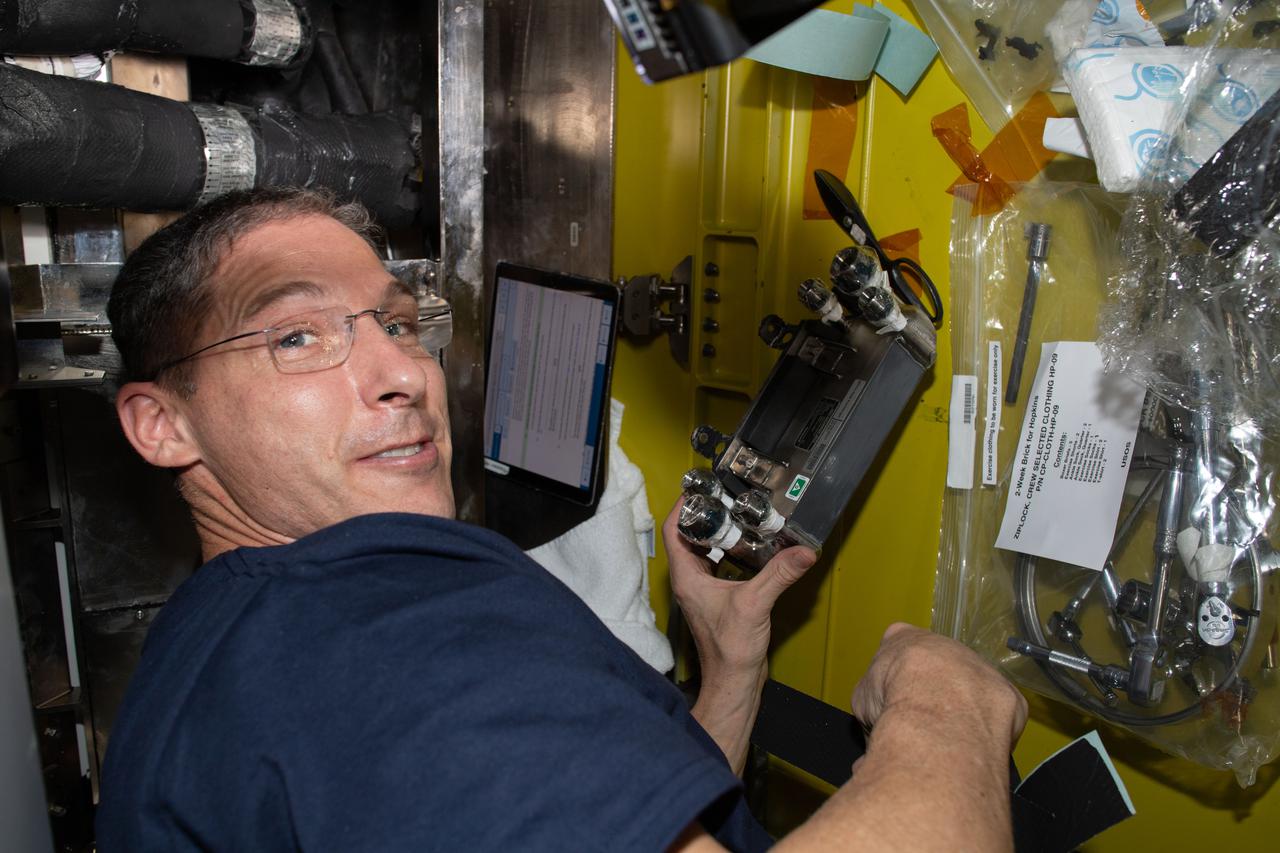 iss064e023920 (Jan. 19, 2021) --- NASA astronaut and Expedition 64 Flight Engineer Michael Hopkins works on U.S. spacesuit maintenance inside the Quest airlock of the International Space Station.