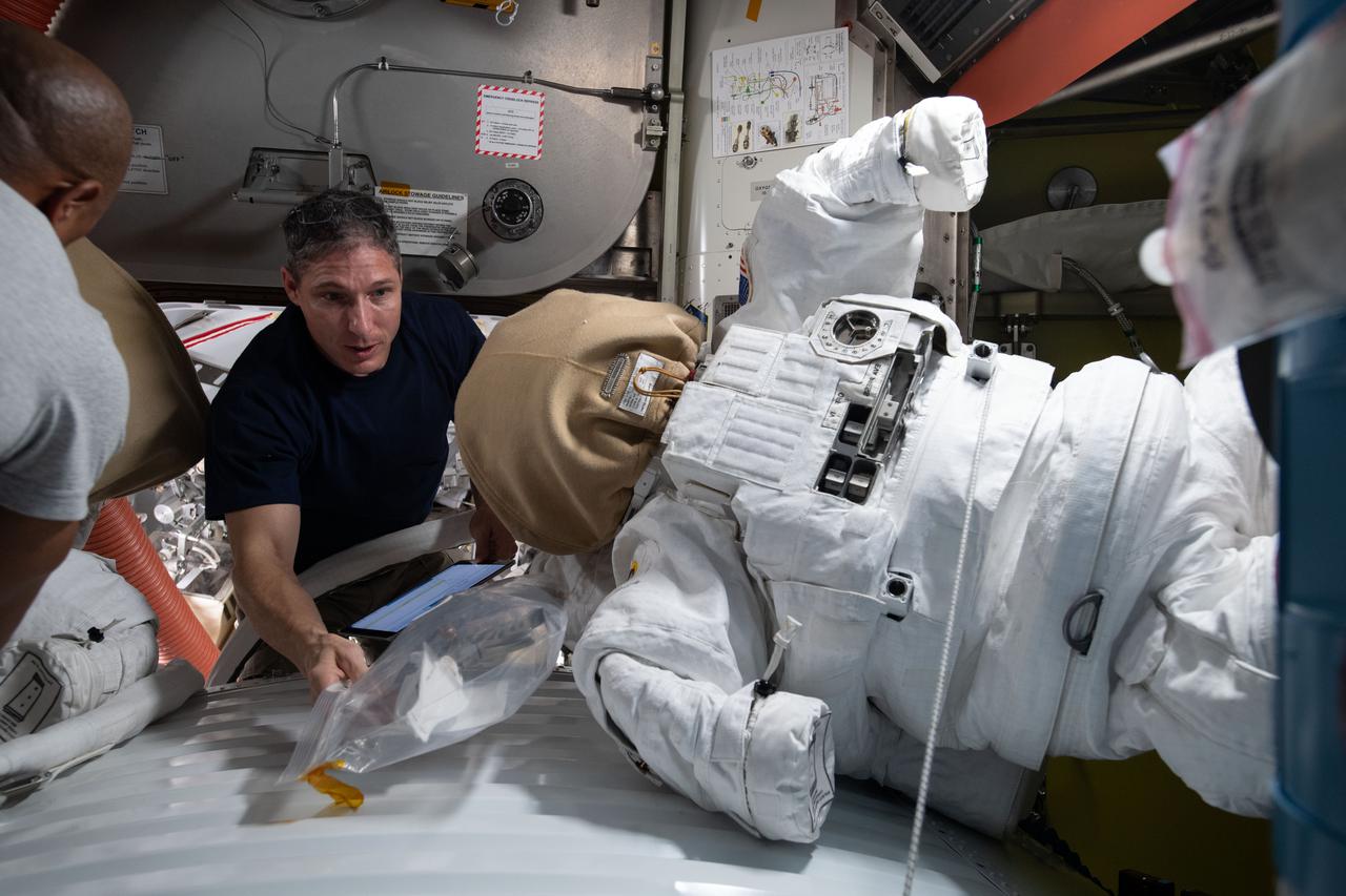 iss064e023961 (Jan. 19, 2021) --- NASA astronaut and Expedition 64 Flight Engineer Michael Hopkins works on U.S. spacesuit maintenance inside the Quest airlock of the International Space Station.