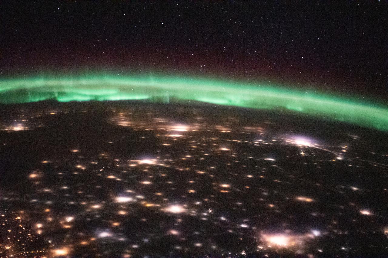iss064e024095 (Jan. 18, 2021) --- The International Space Station was orbiting 263 miles above Ukraine when this photograph was taken of the city lights and an aurora above Russia. Credit: Roscosmos