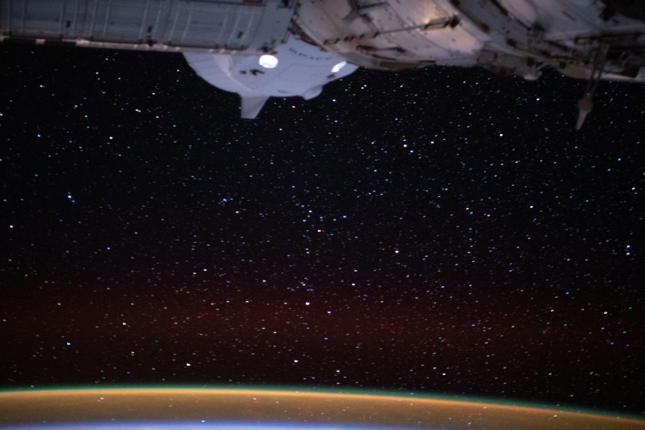 iss064e025506 (Jan. 21, 2021) --- The SpaceX Crew Dragon spaceship, with its two lit crew windows, is pictured docked to the Harmony module's international docking adapter as the International Space Station orbited 264 miles above the North Atlantic off the coast of Ireland.