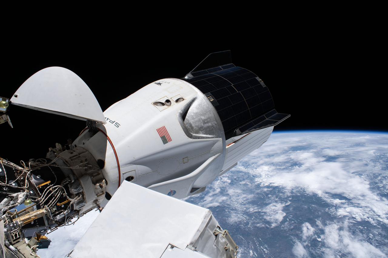 iss064e027440 (Jan. 27, 2021) --- The SpaceX Crew Dragon spacecraft, with its nose cone open, is pictured docked to the Harmony module's forward international docking adapter. The International Space Station was orbiting 264 miles above southern Brazil when this photograph was taken.
