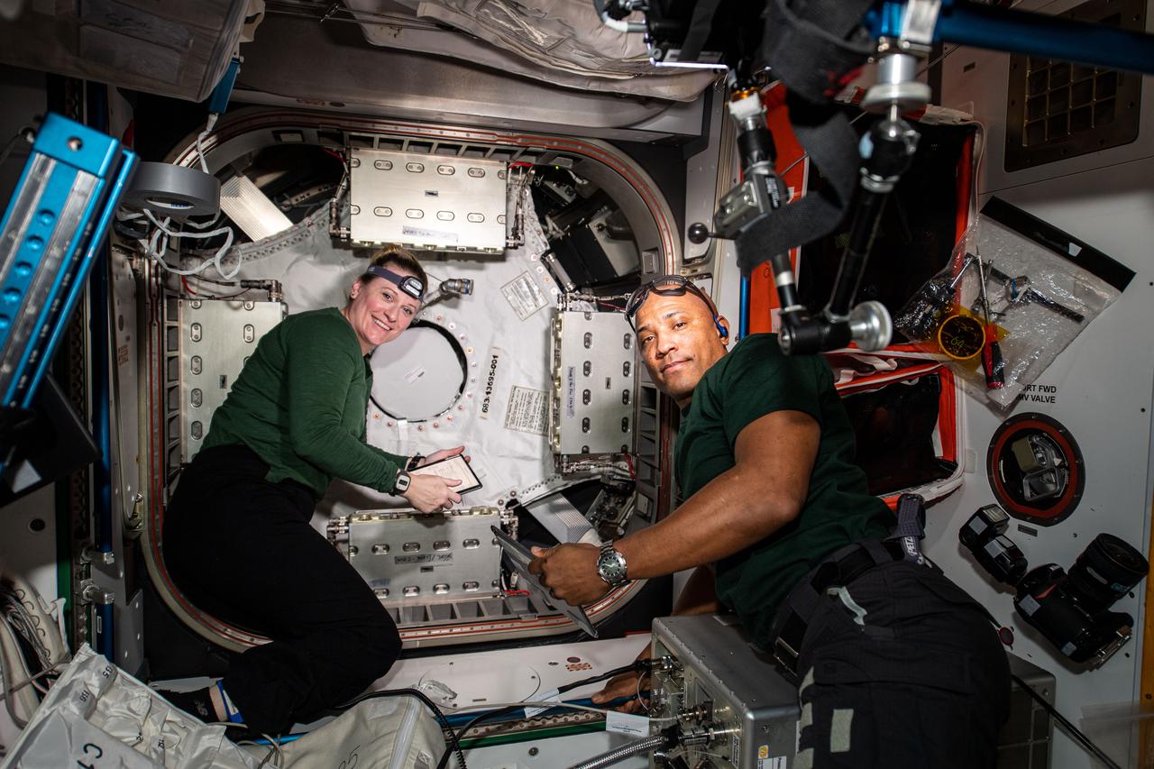 iss064e030013 (Feb. 8, 2021) --- NASA astronauts and Expedition 64 Flight Engineers Kate Rubins and Victor Glover work to configure and open the NanoRacks Bishop airlock attached to the Tranquility module. Bishop will enable more commercial research, satellite deployments, and cargo operations outside in the vacuum of space.