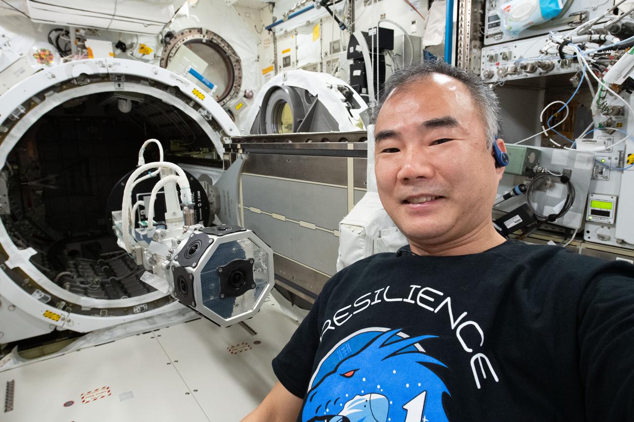 iss064e035270 (Feb. 23, 2021) --- JAXA (Japan Aerospace Exploration Agency) astronaut and Expedition 64 Flight Engineer Soichi Noguchi is pictured after installing a three-dimensional virtual reality camera on the Kibo laboratory module's airlock slide table. The camera films activities aboard the orbiting lab in cinematic virtual reality to document living and working in space for audiences on Earth as part of the ISS Experience investigation.