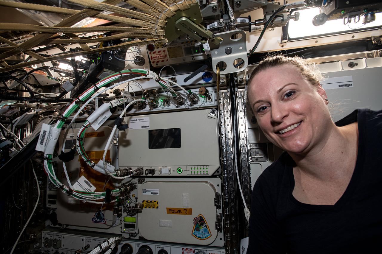 iss064e037167 (Feb. 23, 2021) --- NASA astronaut and Expedition 64 Flight Engineer Kate Rubins poses next to the TangoLab Facility that she had finished installing into an EXPRESS rack located inside the International Space Station's U.S. Destiny laboratory module. The TangoLab is a small research facility that enables a variety of microgravity science, research and development, and pilot manufacturing opportunities.