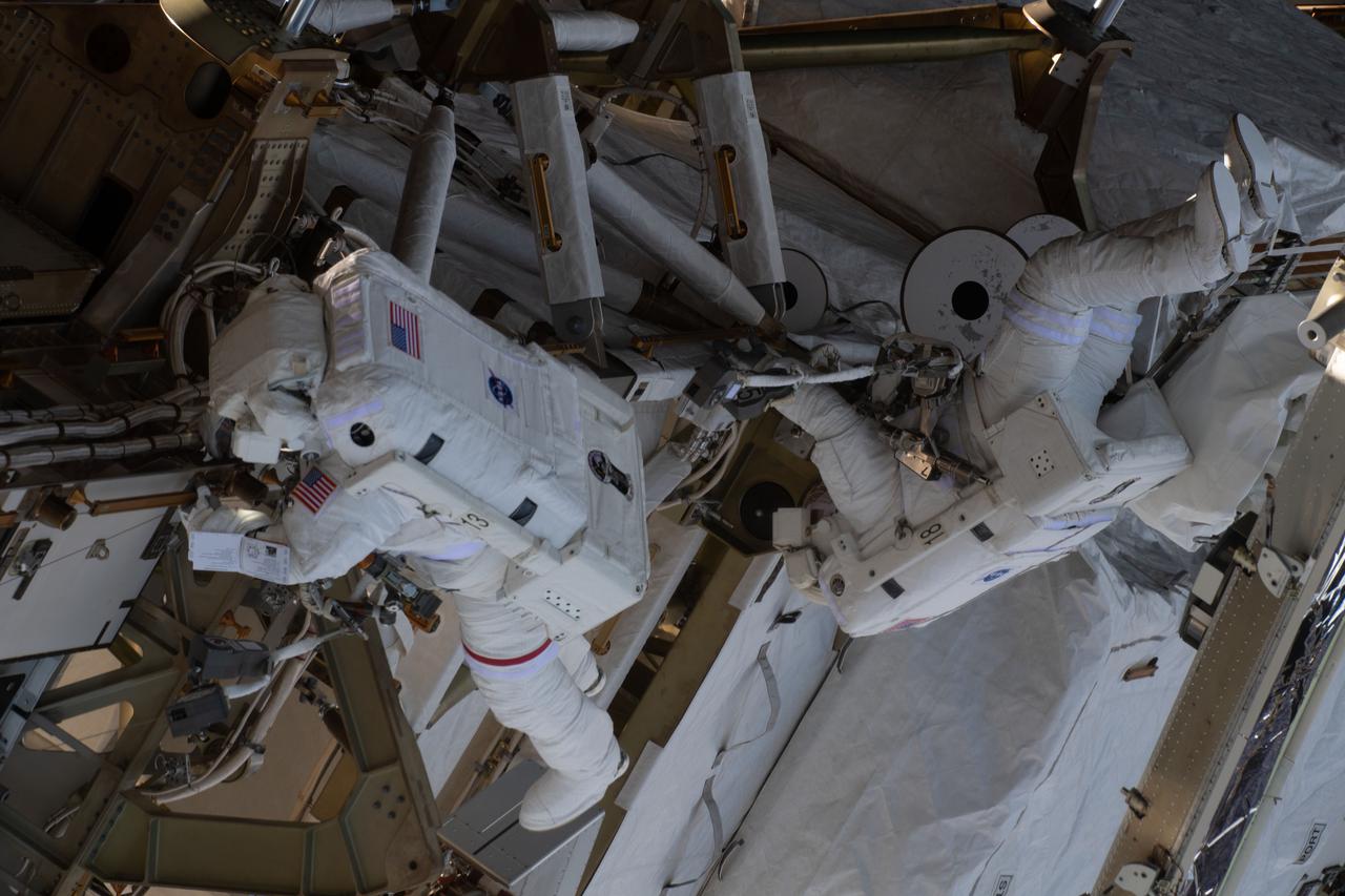 iss064e038352 (Feb. 28, 2021) -- -NASA astronauts Kate Rubins (left) and Victor Glover (right) are pictured during a spacewalk to install solar array modification kits on the International Space Station. The maintenance work will support new, more powerful solar arrays that will be delivered on upcoming SpaceX Dragon cargo missions.