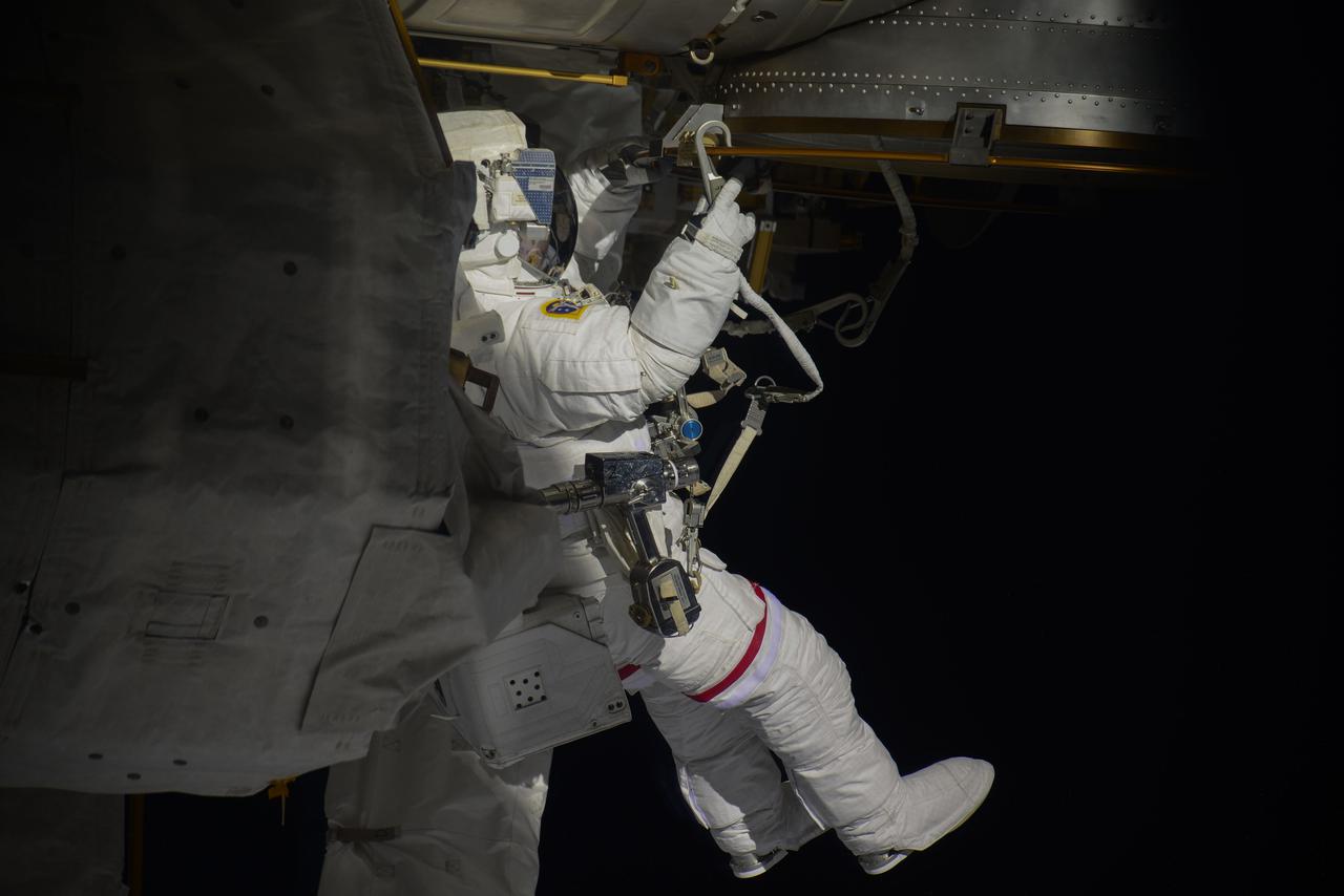 iss064e039323 (Feb. 28, 2021) --- NASA astronaut Kate Rubins is pictured during a spacewalk to install solar array modification kits on the International Space Station. The maintenance work will support new, more powerful solar arrays that will be delivered on upcoming SpaceX Dragon cargo missions. Credit: Roscosmos