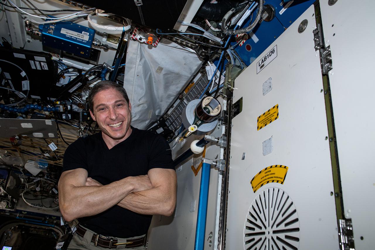 Working in microgravity creates new challenges, even for simple tasks. Next to a floating Hopkins is a HUNCH Tape Dispenser specialized for operations in microgravity. This tape dispenser, developed by high school students through the NASA HUNCH (High Schools United with NASA to Create Hardware) program, requires only one hand to cut pieces of tap. This improves crew efficiency and addresses human factors that must be considered when working in the microgravity environment.