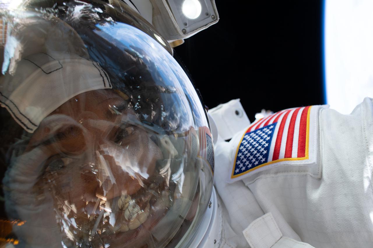 iss064e041899 (March 13, 2021) --- NASA astronaut and Expedition 64 Flight Engineer Victor Glover takes a "space-selfie" with his helmet's visor down during a spacewalk to service the station’s cooling system and communications gear with fellow NASA spacewalker Michael Hopkins (out of frame).