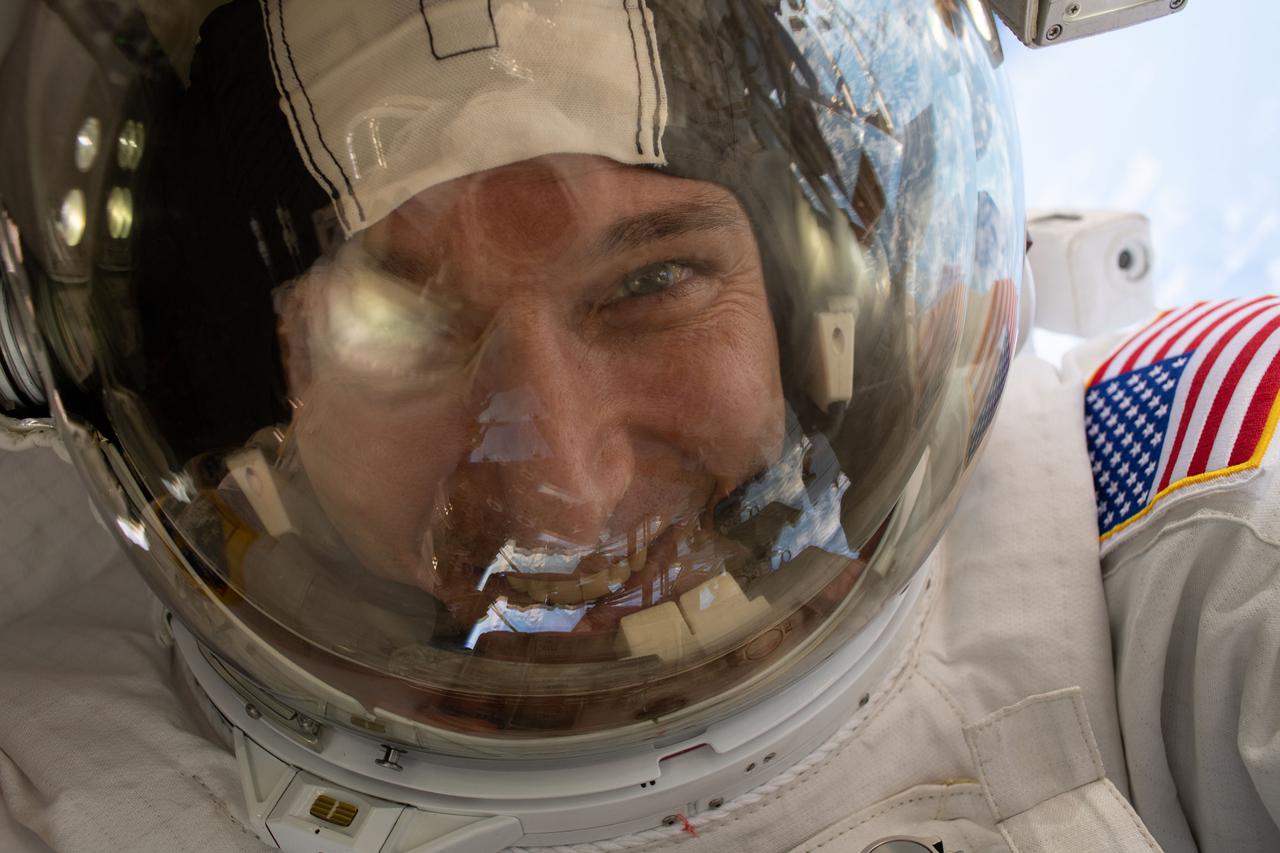 iss064e042327 (March 13, 2021) --- NASA astronaut and Expedition 64 Flight Engineer Michael Hopkins takes a "space-selfie" with his helmet's visor down during a spacewalk to service the station’s cooling system and communications gear with fellow NASA spacewalker Victor Glover (out of frame).