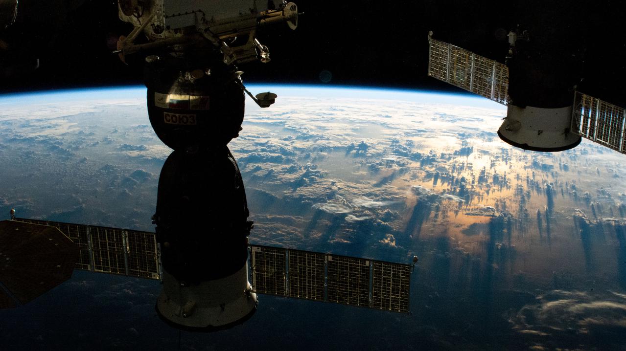 iss064e044526 (March 19, 2021) --- Two Russian spaceships (from left), the Soyuz MS-17 crew ship and the ISS Progress 77 cargo craft, are pictured docked to the International Space Station as it orbited into a sunrise 264 miles above the South Pacific.