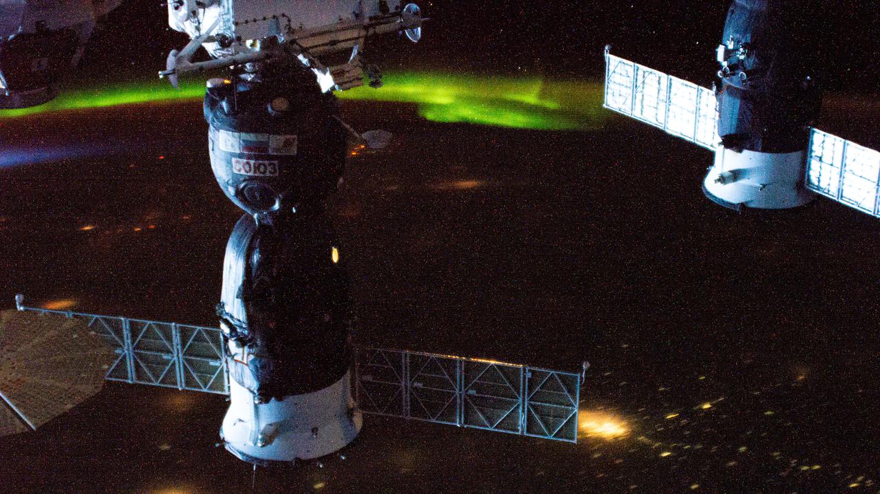 iss064e044527 (March 19, 2021) --- Two Russian spaceships (from left), the Soyuz MS-17 crew ship and the ISS Progress 77 cargo craft, are pictured docked to the International Space Station as it orbited 264 miles above Kazakhstan with an aurora glowing near the horizon.