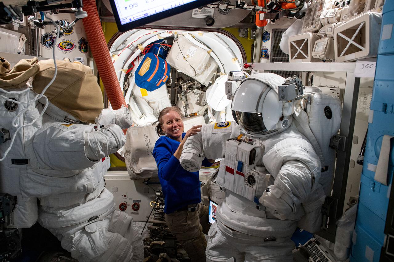 iss064e044598 (March 19, 2021) --- Astronaut and Expedition 64 Flight Engineer Shannon Walker of NASA installs high-definition video cameras and lithium-ion power adapters on U.S. spacesuits located inside the International Space Station's Quest airlock.