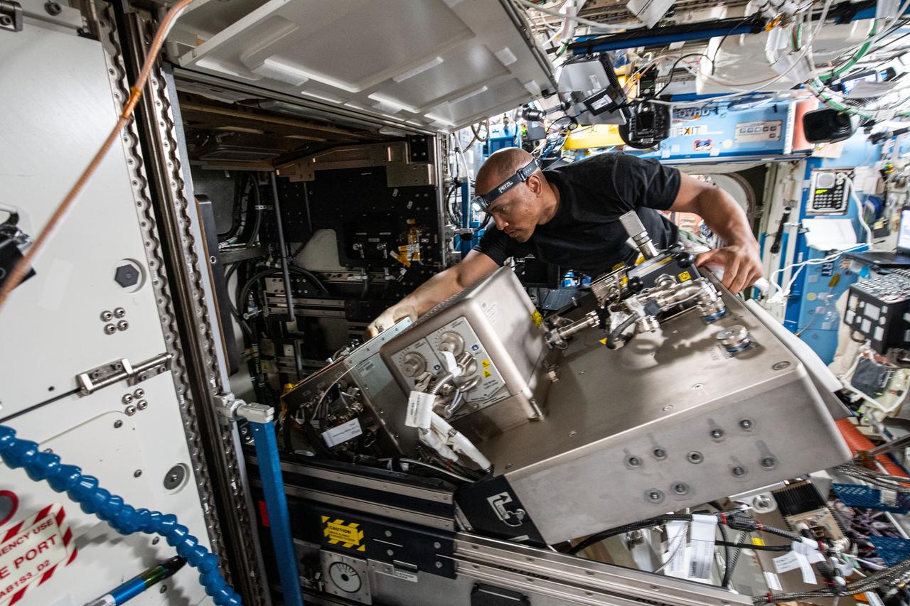iss064e044807 (March 19, 2021) --- NASA astronaut and Expedition 64 Flight Engineer Victor Glover replaces hardware inside the U.S. Destiny laboratory module's Fluids Integrated Rack (FIR). The FIR supports fluid physics research in microgravity observing phenomena such as colloids, gels, bubbles, wetting and capillary action, and phase changes, including boiling and condensation.