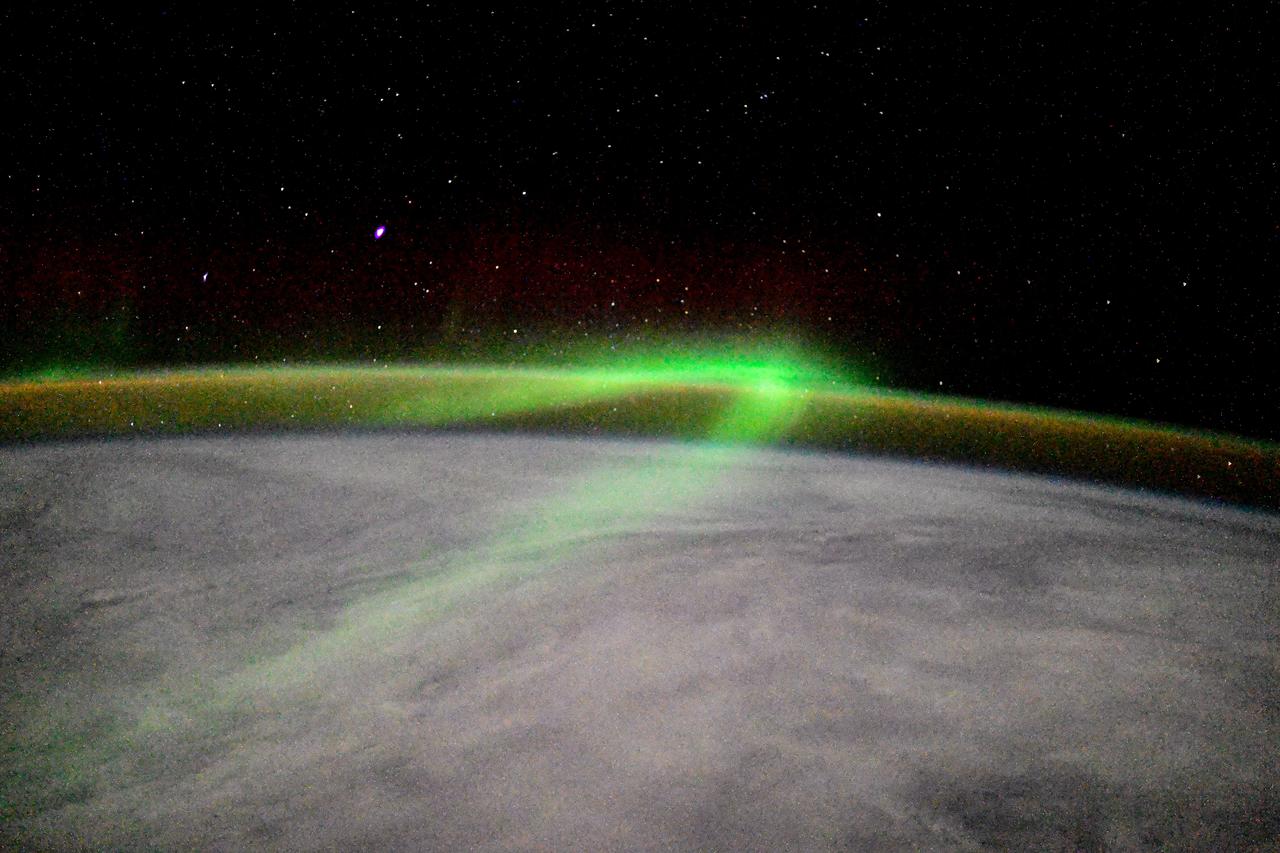 iss064e053179 (April 2, 2021) --- The aurora is pictured streaming above the Earth seemingly intersecting with the airglow as the International Space Station orbited 271 miles over the Indian Ocean southwest of Australia. Credit: Roscosmos
