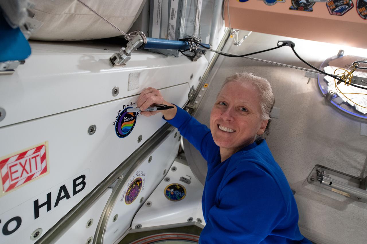 iss064e053418 (April 6, 2021) --- NASA astronaut and Expedition 64 Flight Engineer Shannon Walker applies her signature to the Unity module's vestibule that leads to the Cygnus space freighter from Northrop Grumman.