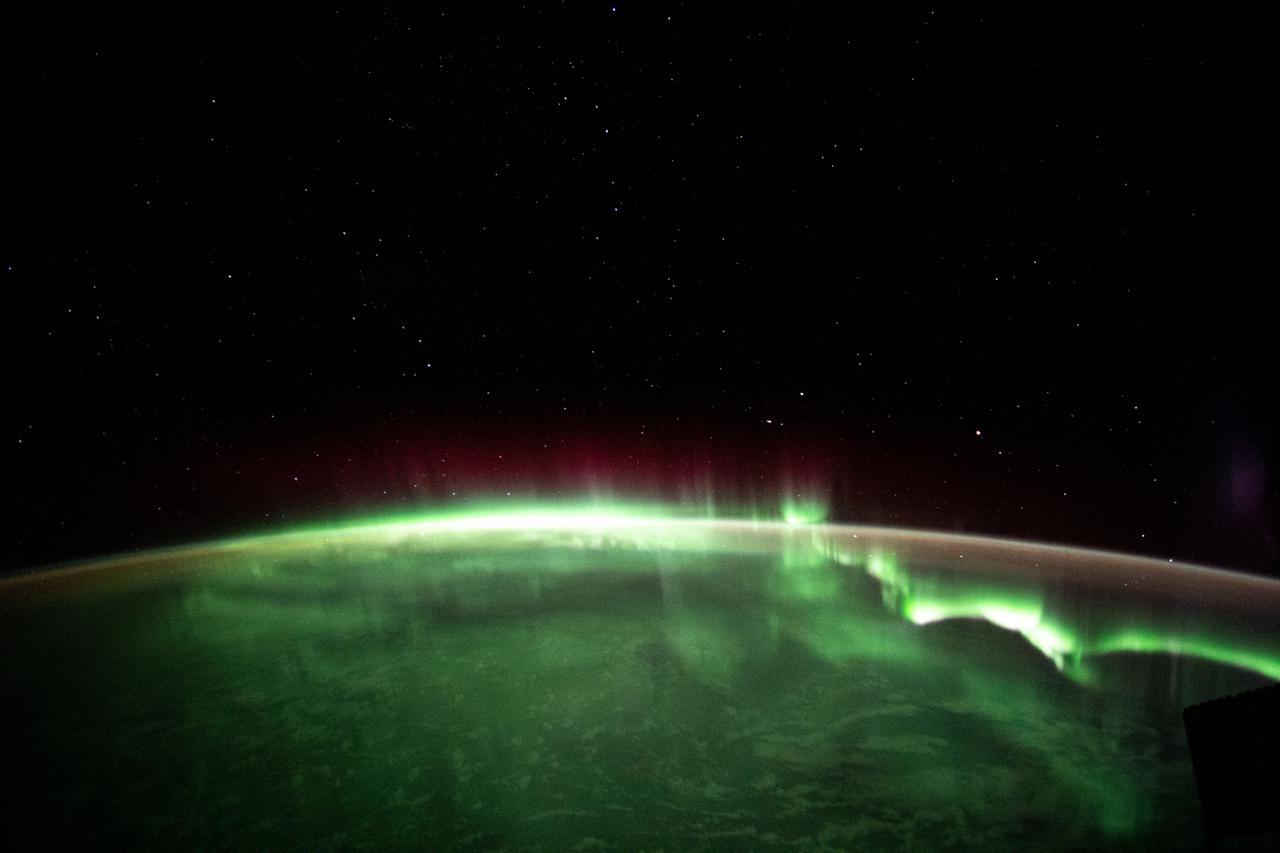 iss065e001065 (April 19, 2021) --- An aurora is pictured streaming above the Earth from a window aboard the SpaceX Crew Dragon Resilience. The International Space Station was orbiting 271 miles above the Indian Ocean in between Australia and Antarctica.