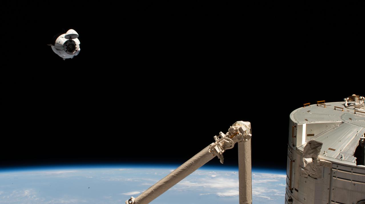 iss065e002827 (April 24, 2021) --- The SpaceX Crew Dragon Endeavour is pictured 262 miles above the Arabian Sea during its approach to the International Space Station. In the bottom right foreground, are portions of the Kibo laboratory module and the Japanese robotic arm, both from the Japan Aerospace Exploration Agency.